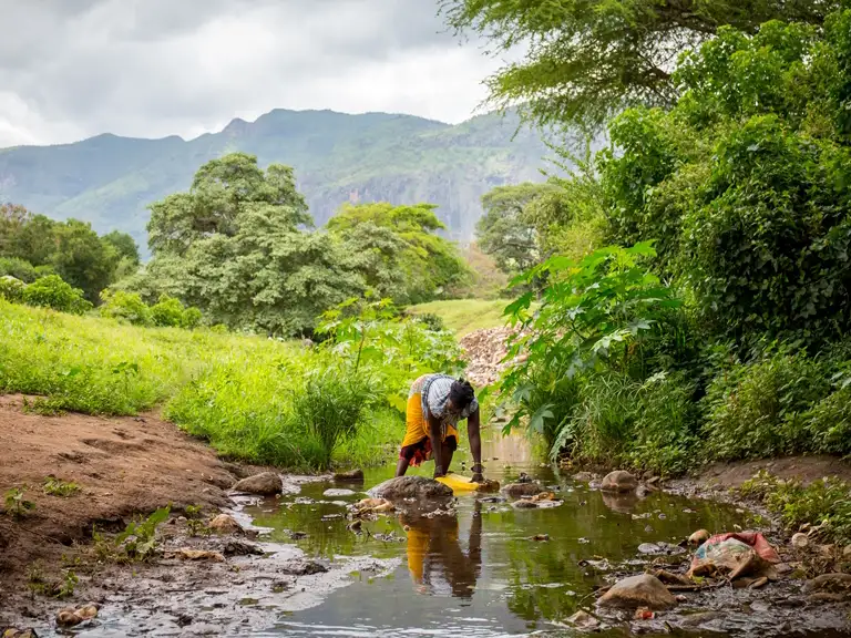 Africa - Uganda - Teko Anna collects water from a river